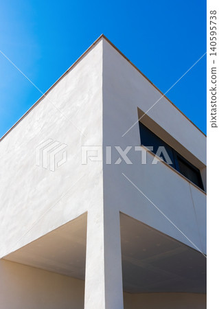 Modern White Building Corner Against Clear Blue Sky Modern White Building Corner Against Clear Blue Sky 140595738