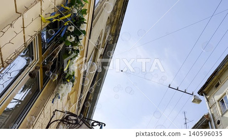 Soap bubbles float through sunlit city street with beautiful architecture in background. The light reflects on their transparent surfaces creating playful and airy summer mood in an urban environment 140596035