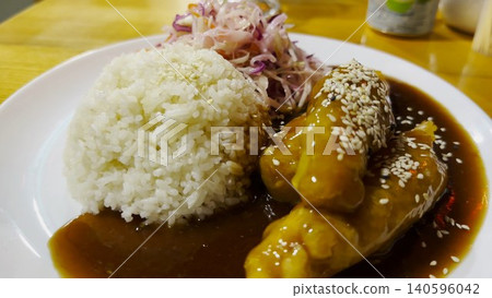 Traditional vietnamese dish arranged on plate at restaurant table. Steamed rice paired with tender chicken and portion of cabbage, creating balanced and inviting composition with clean presentation Traditional vietnamese dish arranged on plate at restaurant table. Steamed rice paired with tender chicken and portion of cabbage, creating balanced and inviting composition with clean presentation 140596042
