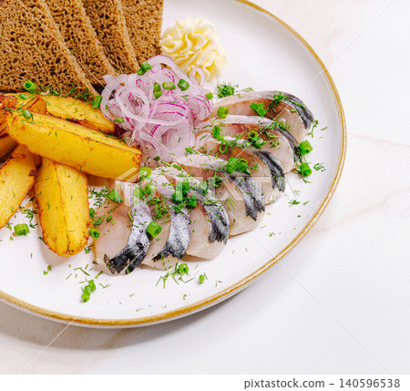 Salted herring fillet with baked potatoes and rye bread Salted herring fillet with baked potatoes and rye bread 140596538