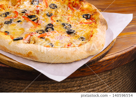 Delicious baked pizza with olives, cheese, and red pepper Delicious baked pizza with olives, cheese, and red pepper 140596554