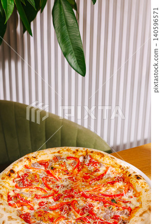 Pizza with red peppers and cheese on restaurant table 140596571