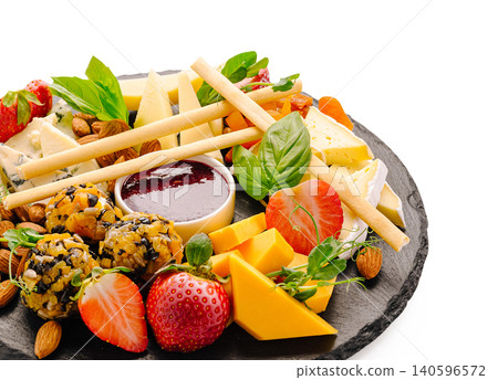 Cheese platter with fruit nuts jam and crackers 140596572