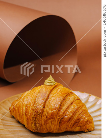 Golden croissant with pistachio cream on plate Golden croissant with pistachio cream on plate 140596576