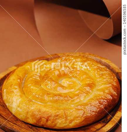 Freshly baked golden brown burek spiral pastry 140596585