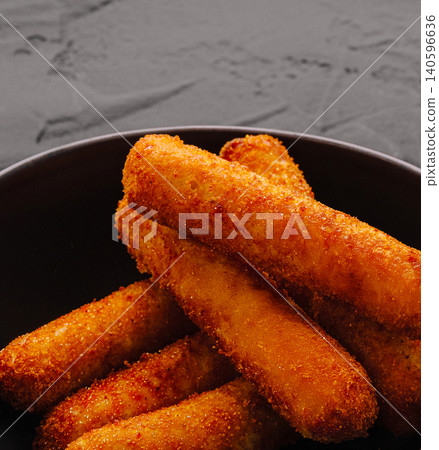 Golden brown fried mozzarella sticks in black bowl Golden brown fried mozzarella sticks in black bowl 140596636