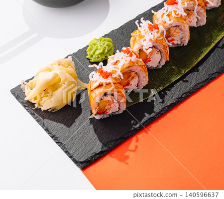 Sushi rolls with mango and roe on slate Sushi rolls with mango and roe on slate 140596637