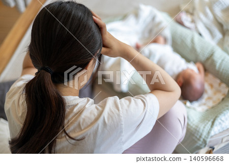 A young mother is exhausted and overwhelmed by childcare. A young mother is exhausted and overwhelmed by childcare. 140596668