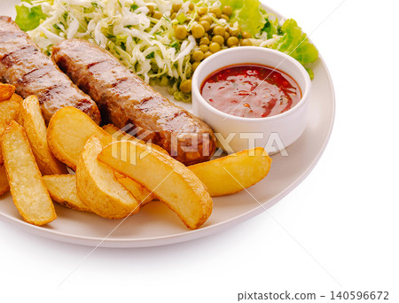 Grilled kebab sausages with potato wedges and fresh salad Grilled kebab sausages with potato wedges and fresh salad 140596672