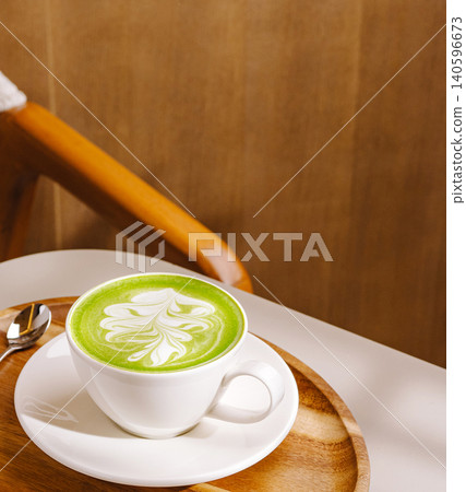 Matcha latte with latte art on wooden tray Matcha latte with latte art on wooden tray 140596673