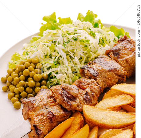 Grilled meat skewer with potato wedges and fresh salad Grilled meat skewer with potato wedges and fresh salad 140596715