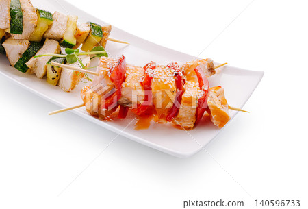 Chicken and salmon skewers with grilled vegetables on white plate Chicken and salmon skewers with grilled vegetables on white plate 140596733