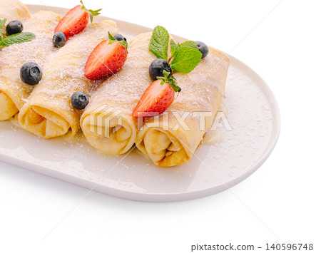 Rolled pancakes with fresh berries and mint leaves Rolled pancakes with fresh berries and mint leaves 140596748