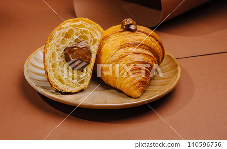 Croissant filled with chocolate hazelnut cream on plate Croissant filled with chocolate hazelnut cream on plate 140596756