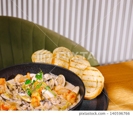 Seafood stew in dark bowl with toasted bread Seafood stew in dark bowl with toasted bread 140596766