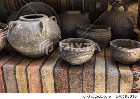 A collection of rustic handmade clay pottery bowls and jars 140596936