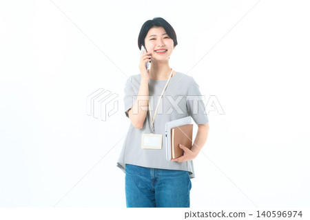 A young woman laughing loudly while talking on the phone against a white background. A young woman laughing loudly while talking on the phone against a white background. 140596974