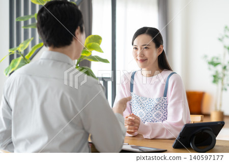 A housewife and a construction worker discussing renovation plans. A housewife and a construction worker discussing renovation plans. 140597177