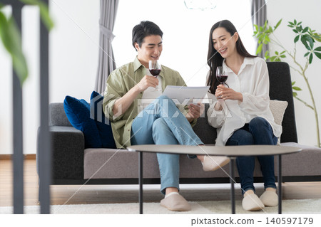 Middle-aged couple drinking wine in the living room 140597179