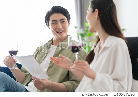 Middle-aged couple drinking wine in the living room Middle-aged couple drinking wine in the living room 140597186