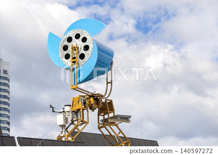 Unique wind turbine design on building with solar panels under cloudy sky Unique wind turbine design on building with solar panels under cloudy sky 140597272