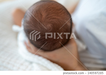 母親抱著嬰兒時,嬰兒的頭頂。 母親抱著嬰兒時,嬰兒的頭頂。 140597285