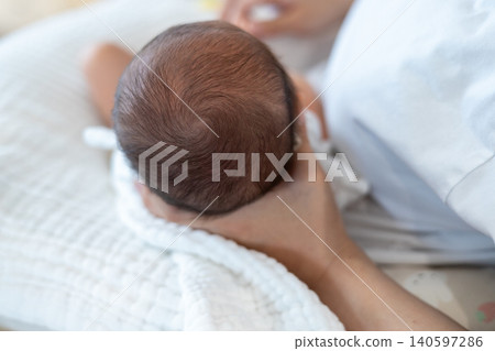 母親抱著嬰兒時,嬰兒的頭頂。 母親抱著嬰兒時,嬰兒的頭頂。 140597286