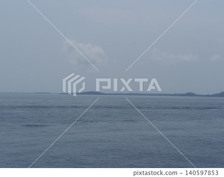 Calm sea horizon cloudy sky distant island tranquil seascape with calm water under overcast sky 140597853