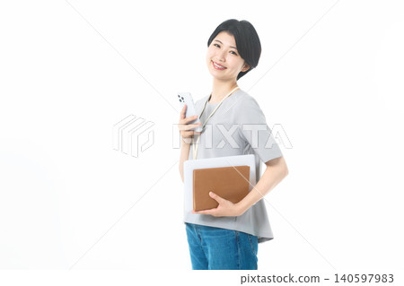 一位年輕女子在白色背景前微笑,手中拿著智慧型手機和文件。 一位年輕女子在白色背景前微笑,手中拿著智慧型手機和文件。 140597983