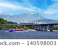 Pink cruise ship on a wide river under beautiful blue sky with majestic mountains 140598003