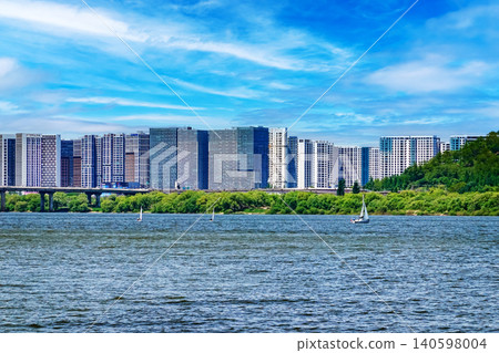 Modern residential apartment buildings along a wide Han river under a bright blue sky Modern residential apartment buildings along a wide Han river under a bright blue sky 140598004