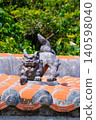 A Shisa (lion-dog statue) sitting on a red tiled roof in Chinen, Okinawa (vertical) 140598040