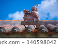 A Shisa (lion-dog statue) sitting on a red tiled roof in Chinen, Okinawa (B) 140598042