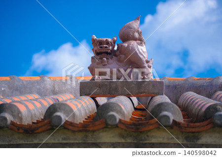 A Shisa (lion-dog statue) sitting on a red tiled roof in Chinen, Okinawa (B) A Shisa (lion-dog statue) sitting on a red tiled roof in Chinen, Okinawa (B) 140598042