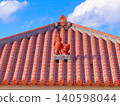 A Shisa (lion-dog statue) sitting on a red tiled roof in Motobu, Okinawa (B) 140598044