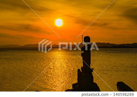 黃昏時的宍道湖:夕陽西下,落日餘暉映照著袖地藏菩薩的輪廓,近距離拍攝。 黃昏時的宍道湖:夕陽西下,落日餘暉映照著袖地藏菩薩的輪廓,近距離拍攝。 140598289