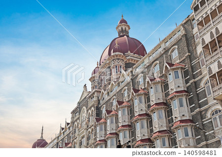Mumbai Maharashtra India Jan 18 2026 Wide angle view of the Taj Mahal Palace Hotel facade and red domes overlooking speedboats at the harbor jetty under a bright blue sky with white clouds Mumbai Maharashtra India Jan 18 2026 Wide angle view of the Taj Mahal Palace Hotel facade and red domes overlooking speedboats at the harbor jetty under a bright blue sky with white clouds 140598481