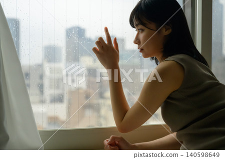 一位年輕女子撫摸著窗戶 一位年輕女子撫摸著窗戶 140598649
