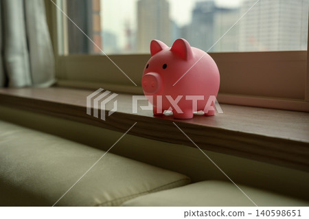 Pink piggy bank by the window 140598651
