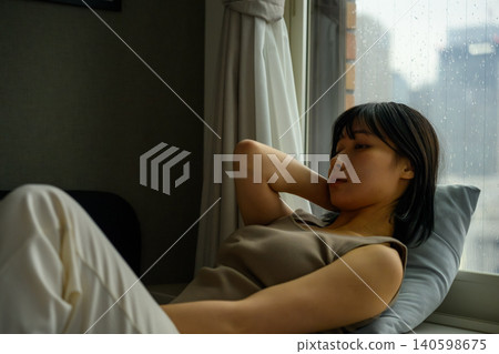 A woman relaxing with her head on a pillow. A woman relaxing with her head on a pillow. 140598675
