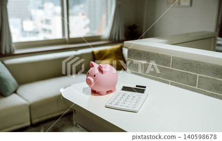 A living room with a piggy bank and a calculator. A living room with a piggy bank and a calculator. 140598678