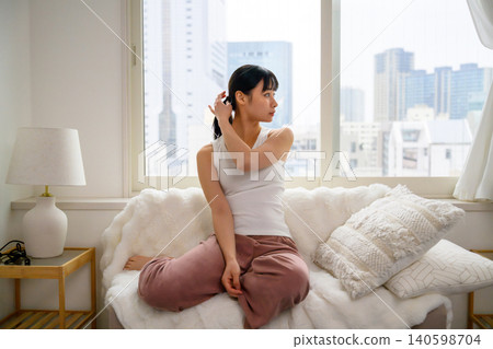 一個年輕女子在沙發上放鬆 140598704