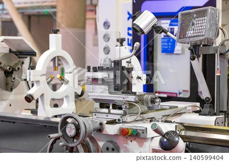 Machine tool setup at a workshop showing equipment and controls during a manufacturing process Machine tool setup at a workshop showing equipment and controls during a manufacturing process 140599404
