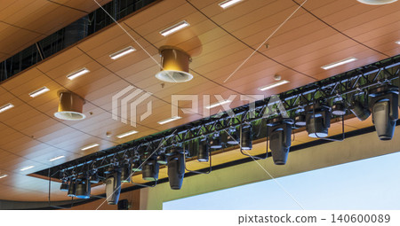 Professional stage lighting equipment hanging on a metal truss system in a modern theater Professional stage lighting equipment hanging on a metal truss system in a modern theater 140600089