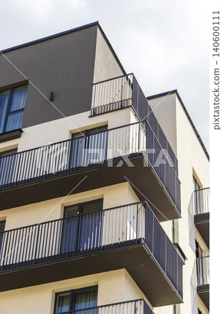 Modern apartment building facade with balconies against a blue sky 140600111