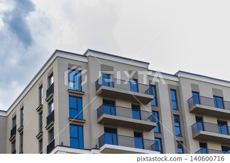 Modern apartment building facade with balconies against a blue sky Modern apartment building facade with balconies against a blue sky 140600716