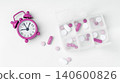 Pill organizer with vitamins and supplements and alarm clock on white background 140600826
