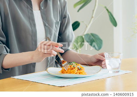 一位年輕女子午餐吃義大利麵。 一位年輕女子午餐吃義大利麵。 140600915