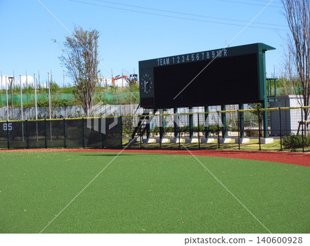 A scene of a game at Myoden Youth Baseball Field, which has beautiful artificial turf, and the scoreboard. 140600928