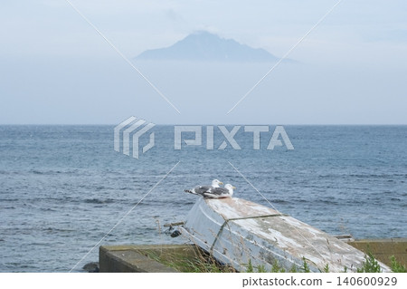 Mount Rishiri and seabirds in a small boat, as seen from Rebun Island. A seascape that conveys the charm of traveling to the northernmost island. 140600929